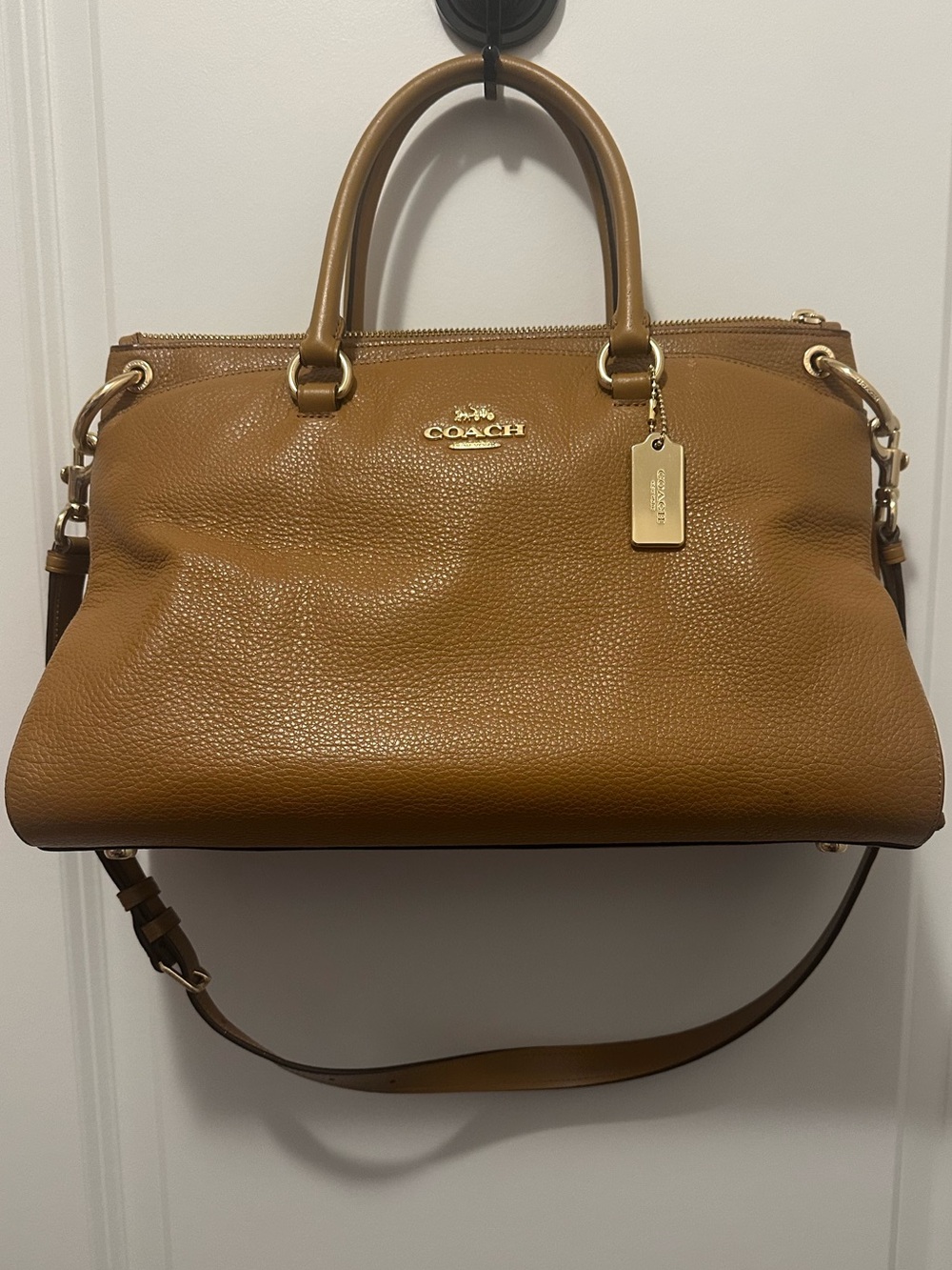 Coach Mia Satchel in a brown, pebbled leather finish.